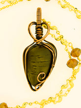 Load image into Gallery viewer, Introducing the #200 Dendritic Dolomite with chain by Copper Den Stone Jewelry: This exquisite teardrop-shaped pendant is encased in oxidized copper wire, featuring a charming heart-shaped detail at the top. It elegantly contrasts against a creamy background and is beautifully complemented by gold chains and amber beads, effortlessly capturing the essence of natural beauty.