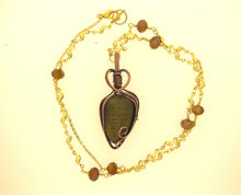 Load image into Gallery viewer, The #200 Dendritic Dolomite with chain by Copper Den Stone Jewelry highlights natural beauty with a Dendritic Dolomite Pendant encased in oxidized copper wire. The chain features wavy links embellished with small brown beads, complementing the allure of its olive-green stone centerpiece.