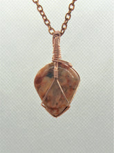 Load image into Gallery viewer, Introducing the #159 Feldspar Point pendant necklace by Copper Den Stone Jewelry, showcasing a polished aventurescent feldspar stone wrapped in oxidized copper wire, all elegantly suspended from a copper chain against a light, textured background.